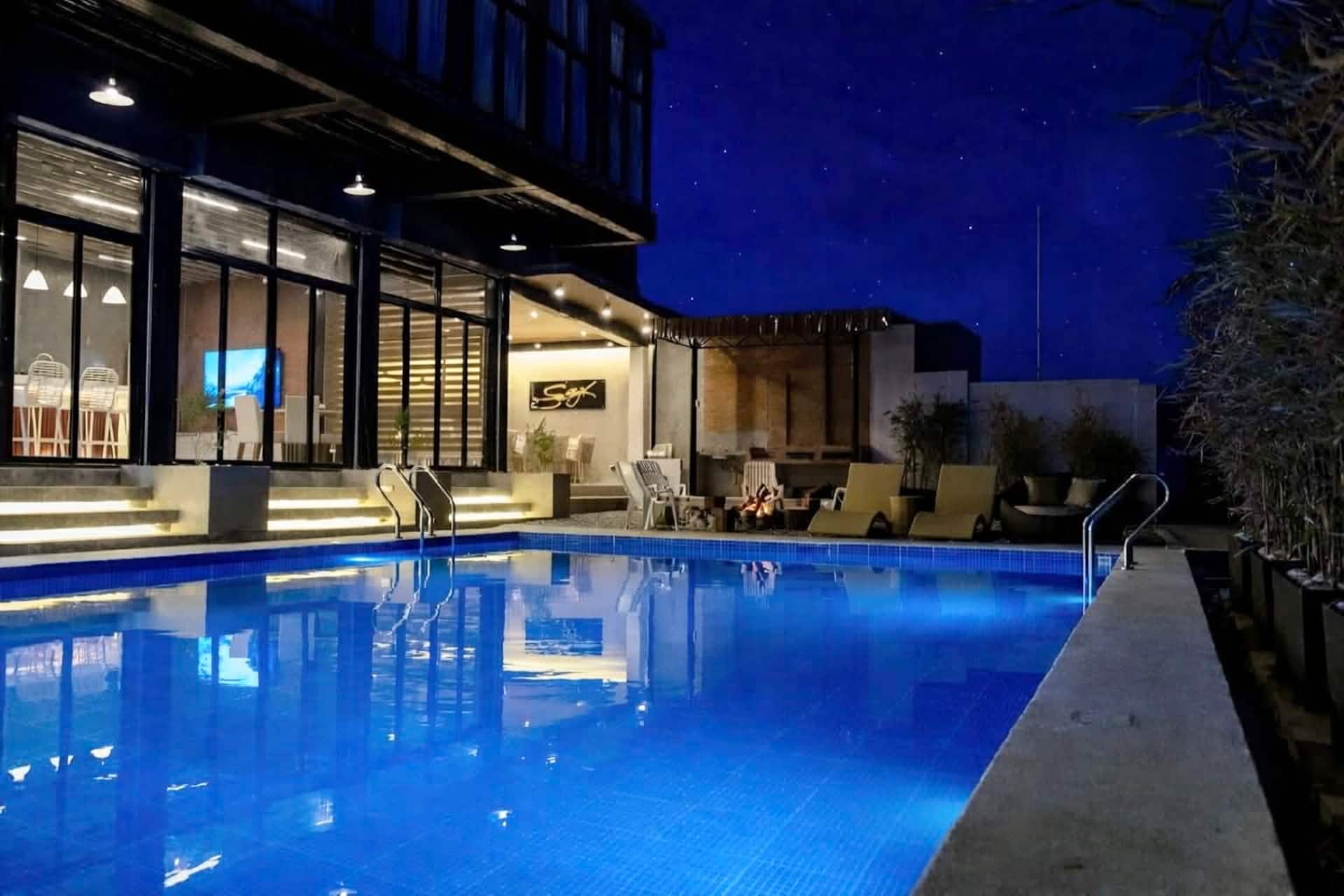 Illuminated private pool and resort exterior at night